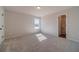 Bedroom featuring neutral carpet, a bright window, and a classic white door at 257 Pinewood Dr, Covington, GA 30014