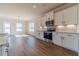 Bright and spacious kitchen with stainless steel appliances, white cabinets, and hardwood floors at 257 Pinewood Dr, Covington, GA 30014
