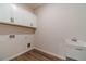 Clean laundry room with hardwood-style floors and white cabinets, plus a utility sink at 257 Pinewood Dr, Covington, GA 30014
