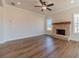 Cozy living room features a brick fireplace, ceiling fan, and large windows offering views of the backyard at 257 Pinewood Dr, Covington, GA 30014