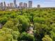 Aerial shot highlighting the neighborhood with skyscrapers, lush green trees, and the home's layout at 277 Alberta Ne Dr, Atlanta, GA 30305