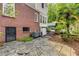 Backyard exterior featuring a brick wall, stone patio, and mature landscaping with a glimpse of a pool area at 277 Alberta Ne Dr, Atlanta, GA 30305