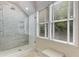 Bathroom features glass enclosed shower with marble tile, window and stone floor at 277 Alberta Ne Dr, Atlanta, GA 30305