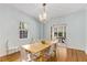 Bright dining room with hardwood floors, modern chandelier, and views of the outdoor greenery at 277 Alberta Ne Dr, Atlanta, GA 30305