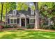 Charming brick home featuring black shutters, dormers, and mature landscaping at 277 Alberta Ne Dr, Atlanta, GA 30305