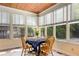 Bright sunroom features a wooden ceiling, multiple windows, and a table set for four at 277 Alberta Ne Dr, Atlanta, GA 30305
