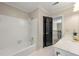 Clean bathroom with tub/shower, vanity, and a dark-colored door at 3060 Robertswood Dr, Powder Springs, GA 30127