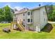 Back of home with a wooden deck and lush trees in background at 3060 Robertswood Dr, Powder Springs, GA 30127