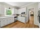 Well-lit kitchen with white cabinets, stainless steel appliances, and hardwood floors at 3060 Robertswood Dr, Powder Springs, GA 30127