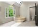Serene main bathroom with soaking tub, skylight, and neutral color scheme for a relaxing experience at 3060 Robertswood Dr, Powder Springs, GA 30127