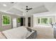 Light-filled main bedroom with large windows overlooking lush greenery, tray ceiling, and neutral walls at 3060 Robertswood Dr, Powder Springs, GA 30127