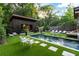 Inviting backyard featuring a pool, spa, lounge chairs, and a charming pool house at 3740 Powers Ferry Nw Rd, Atlanta, GA 30342