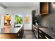 Modern kitchen with gray countertop and stainless steel oven along with black cabinets and an artistic vent hood at 3740 Powers Ferry Nw Rd, Atlanta, GA 30342