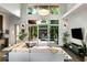 Open-concept living room boasts large windows, comfortable sofa, modern decor, and a bar area with wine storage at 3740 Powers Ferry Nw Rd, Atlanta, GA 30342