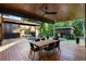 A spacious wooden patio with dining and lounge seating overlooks the yard with sleek, modern architecture in the background at 3740 Powers Ferry Nw Rd, Atlanta, GA 30342