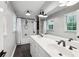 Bright bathroom featuring double vanity, subway tiled shower/tub, and a large mirror at 1130 Angelo Ne Ct, Atlanta, GA 30319