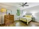Sunlit bedroom with hardwood floors, a ceiling fan, and a comfortable bed with yellow accents at 1130 Angelo Ne Ct, Atlanta, GA 30319