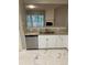 Bright kitchen with stainless steel dishwasher, white cabinets, granite countertop, and tile flooring at 1295 Kilmington Ct, Alpharetta, GA 30009