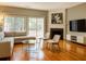 Sun-filled living room featuring a fireplace, large windows, hardwood floors, and stylish furniture at 1295 Kilmington Ct, Alpharetta, GA 30009
