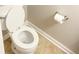 Bright bathroom features a standard toilet with an open lid, tile floors, and a neatly placed roll of toilet paper at 1295 Kilmington Ct, Alpharetta, GA 30009