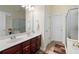 Well-lit bathroom with double sink vanity, tiled floor, and shower and tub at 401 Azalea Cv, Canton, GA 30114