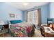 Stylish bedroom with blue walls, colorful bedspread and large window at 401 Azalea Cv, Canton, GA 30114