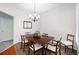 Formal dining room with neutral paint, hardwood floors, decorative rug, and bright chandelier at 401 Azalea Cv, Canton, GA 30114