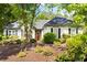 Charming single-story home featuring a well-manicured front yard with lush landscaping and a welcoming red front door at 401 Azalea Cv, Canton, GA 30114