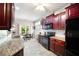 The kitchen features cherry cabinets, granite counters and stainless appliances at 401 Azalea Cv, Canton, GA 30114