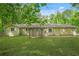 View of the backyard of this lovely home featuring a lush lawn and a wooden pergola over the back door at 9955 Rivertown Rd, Fairburn, GA 30213