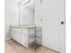 Bright bathroom features a granite-topped vanity with white cabinets, a large mirror, and a tiled floor at 9955 Rivertown Rd, Fairburn, GA 30213