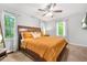 Light-filled bedroom with a comfortable bed, ceiling fan, and tranquil views from the large windows at 9955 Rivertown Rd, Fairburn, GA 30213