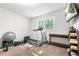 Neutral bedroom showcasing exercise equipment, TV and a large window with green trees outside at 9955 Rivertown Rd, Fairburn, GA 30213