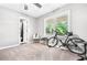 Neutral bedroom with a ceiling fan, large window with green trees and a black bicycle at 9955 Rivertown Rd, Fairburn, GA 30213