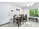 Inviting dining area with a table set for six, a window bench, and stylish light fixture at 9955 Rivertown Rd, Fairburn, GA 30213
