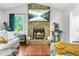 Living room features a stone fireplace, hardwood floors, and large windows offering scenic outdoor views at 9955 Rivertown Rd, Fairburn, GA 30213