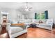 Bright living room with a plush sectional sofa, hardwood floors, and natural light from the window at 9955 Rivertown Rd, Fairburn, GA 30213
