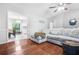 Cozy living area featuring hardwood floors, a comfortable sectional, and a view into the dining area at 9955 Rivertown Rd, Fairburn, GA 30213