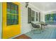 Charming porch area with seating, views, and a welcoming yellow front door with glass pane at 9955 Rivertown Rd, Fairburn, GA 30213