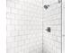 Bright tiled shower showcasing white subway tile, modern fixtures, and ample lighting at 9955 Rivertown Rd, Fairburn, GA 30213