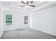 Spacious bedroom with tray ceiling, ceiling fan, and windows providing natural light and a view at 10 Hollow Ct, Covington, GA 30016