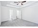Bright bedroom with ceiling fan, tray ceiling, and doorway leading to an ensuite bathroom at 10 Hollow Ct, Covington, GA 30016
