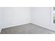 An empty bedroom with fresh grey carpet, white walls, baseboards, and one double-hung window at 10 Hollow Ct, Covington, GA 30016