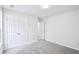 Neutral bedroom with grey carpet, double door closet, white walls, and a doorway leading to an adjacent room at 10 Hollow Ct, Covington, GA 30016