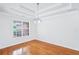 Elegant dining area featuring hardwood floors, decorative chandelier, and a large window offering a pleasant view at 10 Hollow Ct, Covington, GA 30016