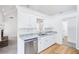 Modern kitchen with granite countertops, stainless steel dishwasher, and view into adjacent living area at 10 Hollow Ct, Covington, GA 30016