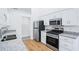 Modern kitchen featuring stainless steel appliances, granite countertops, and wood grain floors at 10 Hollow Ct, Covington, GA 30016