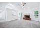 Bright open-concept living area with a fireplace and hardwood floors flowing into a carpeted living space at 10 Hollow Ct, Covington, GA 30016