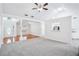 Open-concept living room with a blend of carpet and hardwood floors, enhanced by coffered ceilings and abundant light at 10 Hollow Ct, Covington, GA 30016