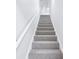 Carpeted stairway with white walls leads to the upper level of the home at 10 Hollow Ct, Covington, GA 30016